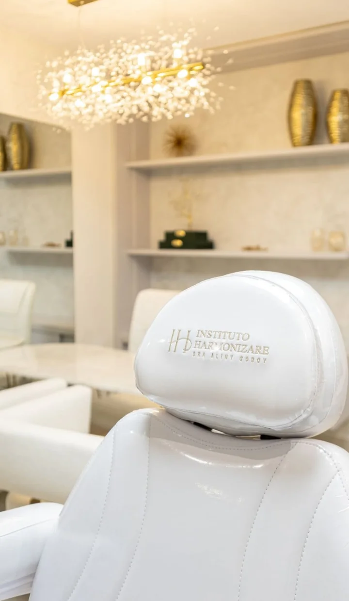 Cadeira de atendimento branca com o logo do Instituto Harmonizare bordado no encosto